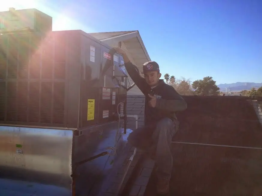 HVAC technician performing Boiler Repair on a rooftop unit in Wagoner